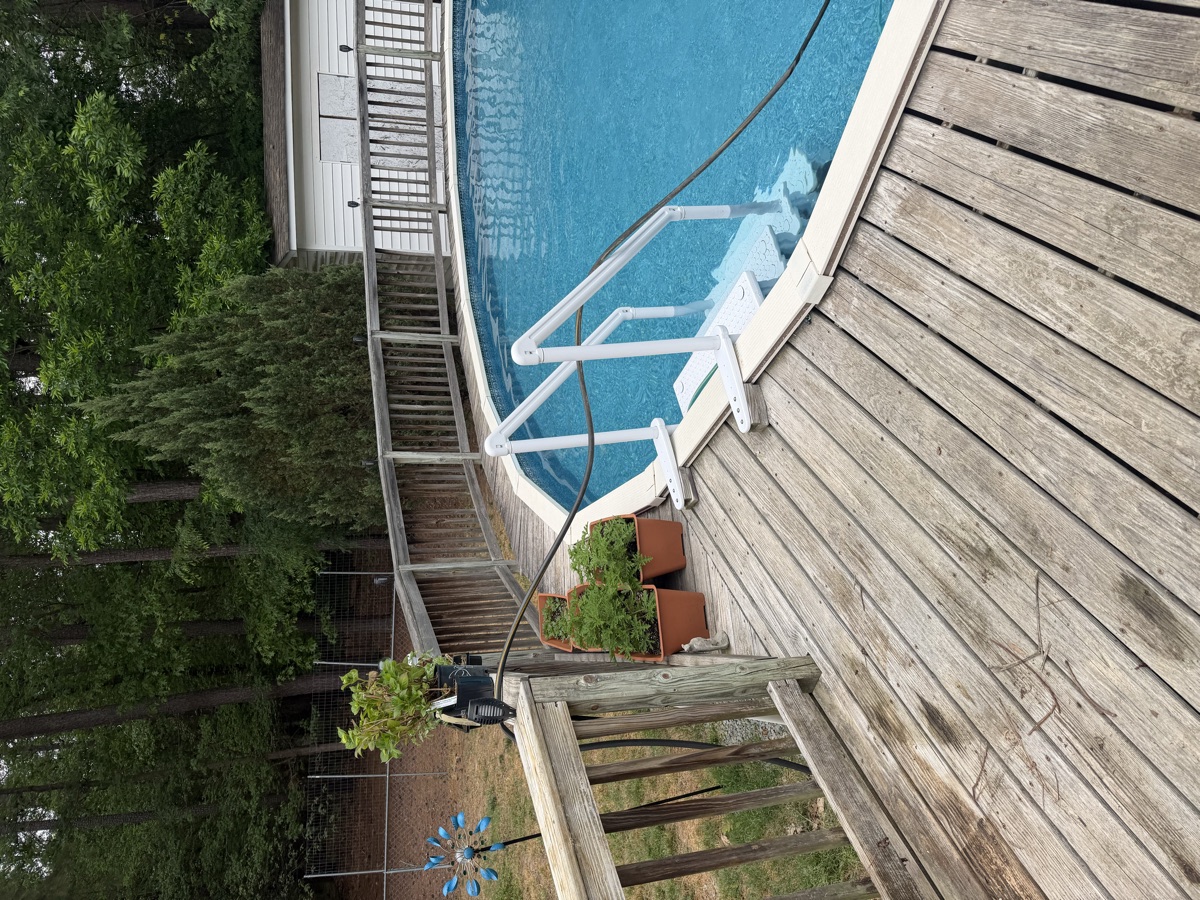 A worn, gray pool deck before rebuild